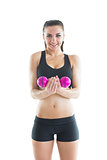 Portrait of happy active woman training using a pink dumbbell