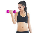 Active young woman using a pink dumbbell for training her arm