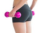 Close up of female bottom while training with pink dumbbells