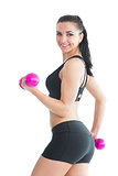 Portrait of smiling active woman training with pink dumbbells
