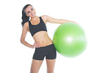 Attractive fit woman posing holding a green exercise ball