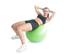 Joyful fit woman doing an exercise on an exercise ball