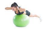 Cute fit woman practicing an exercise on a fitness ball