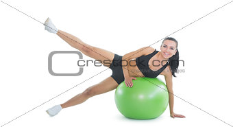Content active woman doing an exercise on a green fitness ball
