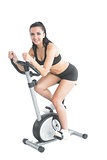 Beautiful ponytailed woman using her exercise bike