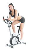 Beautiful young woman training on an exercise bike