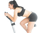 Joyful sporty woman training on an exercise bike