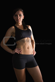 Sporty young woman posing with hands on hips