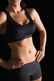 Mid section of slender fit woman posing in sportswear