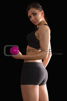 Portrait of beautiful fit woman lifting a pink dumbbell
