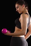 Gorgeous sporty woman lifting a pink dumbbell