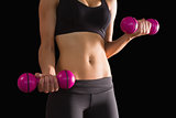 Slender active woman lifting pink dumbbells