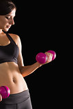 Pretty fit woman lifting pink dumbbells for training her arms