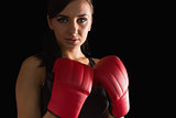 Beautiful sporty woman wearing boxing gloves looking at camera