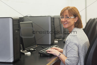 Smiling female mature student using a computer