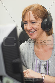 Happy mature woman working on computer