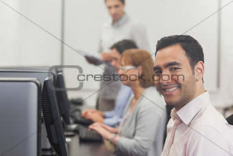 Content mature student sitting in computer class