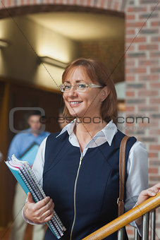 Happy female mature student posing in corridor