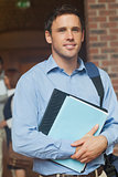 Attractive mature student posing in corridor holding some files