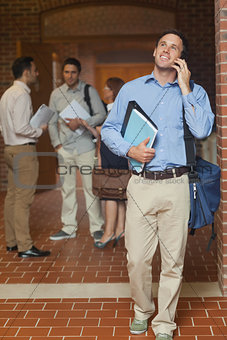 Cheerful handsome mature student phoning with his smartphone