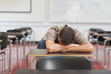 Male mature student lying his head on the desk while sleeping