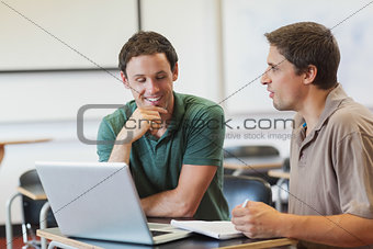 Two attractive mature students learning while sitting in class room