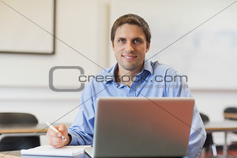 Handsome mature student learning and sitting in classroom