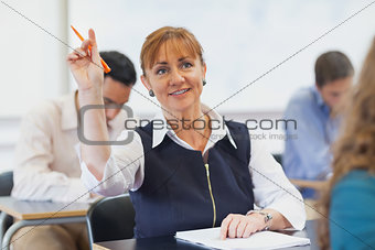 Female mature student raising her hand