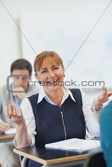 Amused female mature woman sitting in classroom