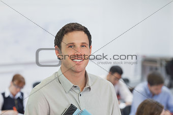 Cute male teacher standing in his classroom