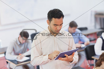 Male teacher working concentrated with his tablet