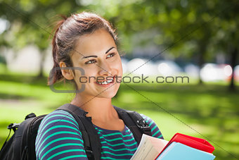 Casual smiling student holding books