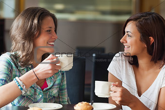 Two smiling students having a cup of coffee