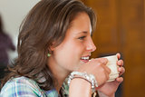 Pretty smiling student drinking a cup of coffee
