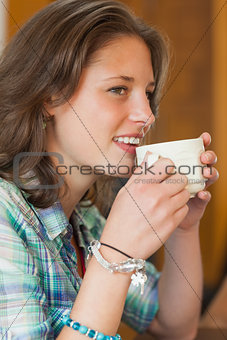 Pretty cheerful student drinking a cup of coffee