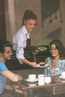 Smiling waitress serving food to a couple