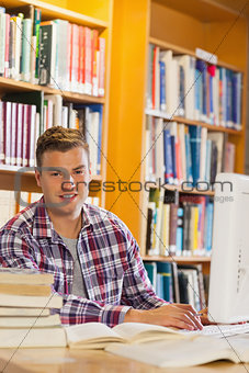 Handsome smiling student using computer