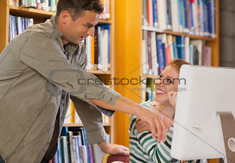 Male student explaining his classmate something on the computer