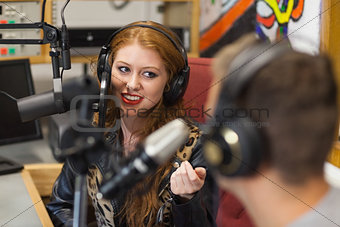 Attractive happy radio host interviewing a guest