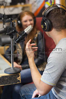 Attractive smiling radio host interviewing a guest