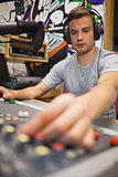 Handsome focused radio host moderating turning up volume