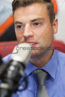 Well dressed concentrating radio host moderating