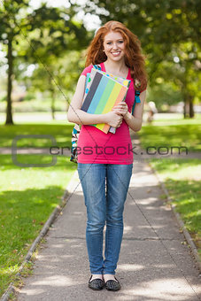 Gorgeous smiling student carrying notebooks