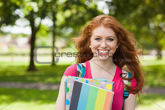 Gorgeous smiling student holding notebooks