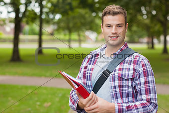 Handsome smiling student carrying folder