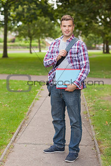 Handsome happy student holding notebook and folder