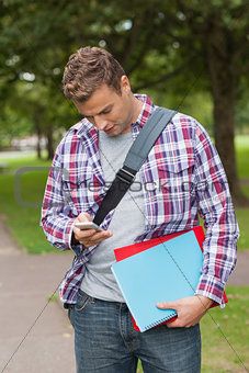 Handsome casual student standing and texting