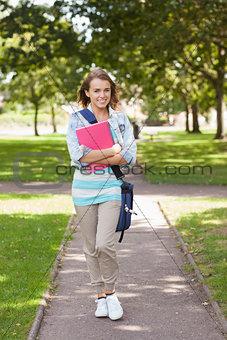 Pretty happy student carrying notebook