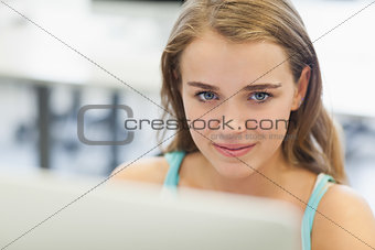 Happy pretty student working on computer