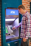 Handsome student withdrawing cash